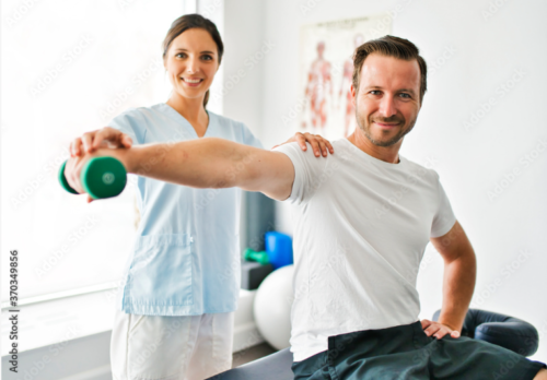 Fizjoterapeutka z pacjentem ćwiczącym z zielonym hantlem