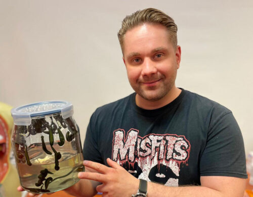 Mężczyzna trzyma w rękach słoik z pijawkami