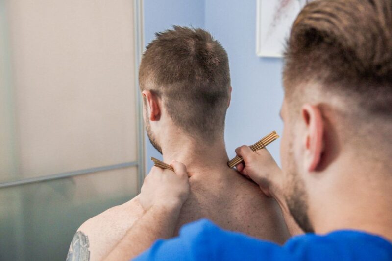 Fizjoterapeuta wykonuje pacjentowi zabieg pinoterapii