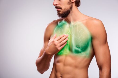 Mężczyzna trzyma dłoń na klatce piersiowej, na klatce piersiowej zielona wizualizacja płuc