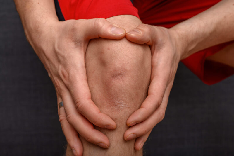 Kolano ze zwyrodnieniem objęte dłońmi